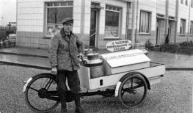 Henk Vleeming met bakfiets voor de winkel Broekveldseweg 49 met RWB FB 12 febr. 2015.jpg